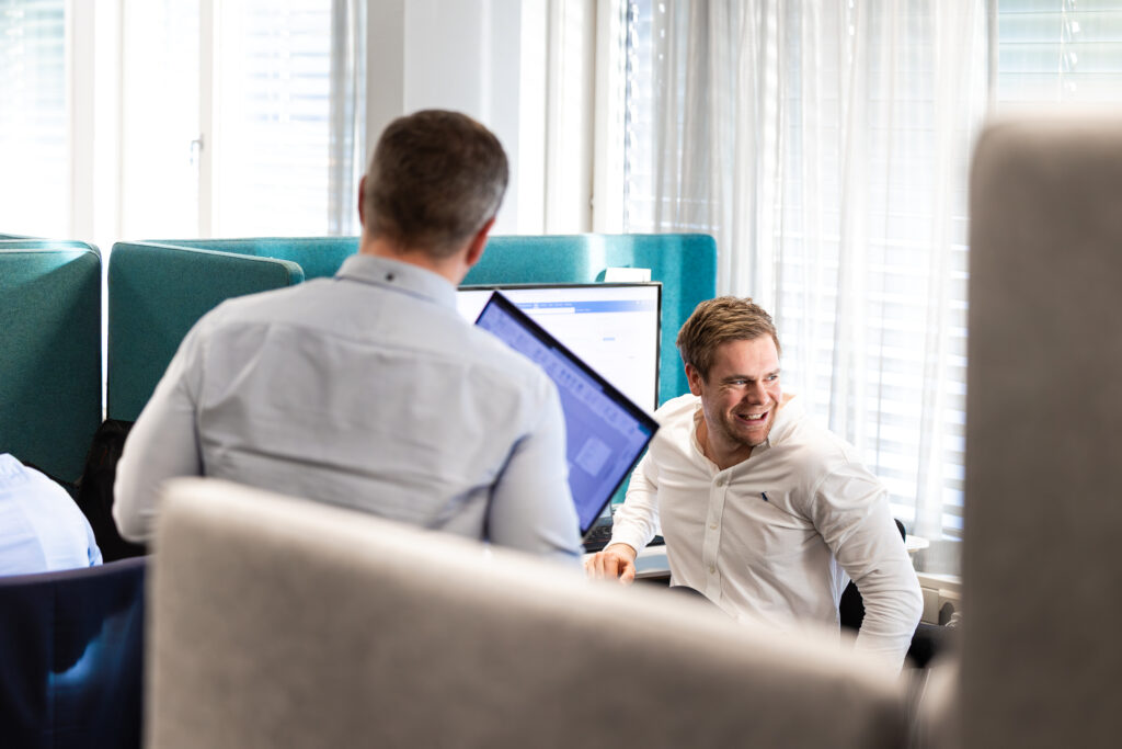 Bilde av en ansatt hos DIB som snakker med kollegaer