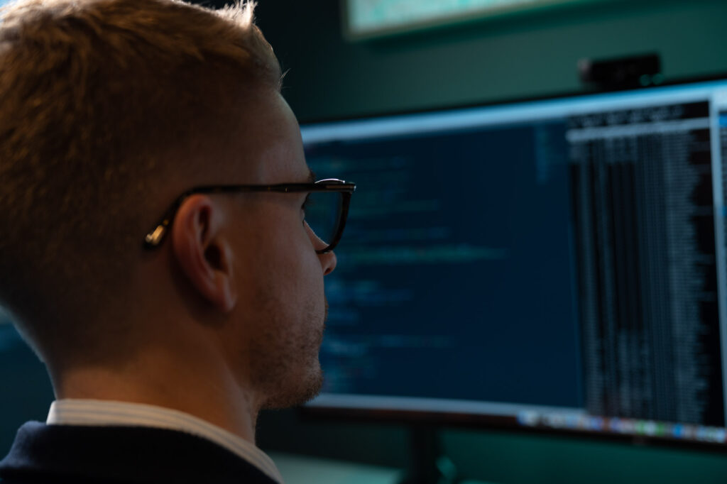 Bilde av en mann som sitter og koder og holder på med å sette opp et servermiljø for drift av hjemmesider