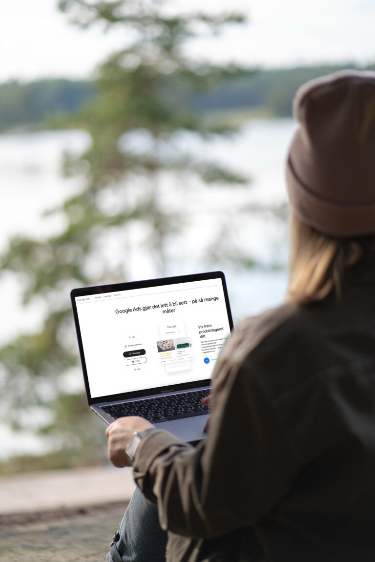 Bilde av en dame som sitter utenfor på en PC og ser på Google