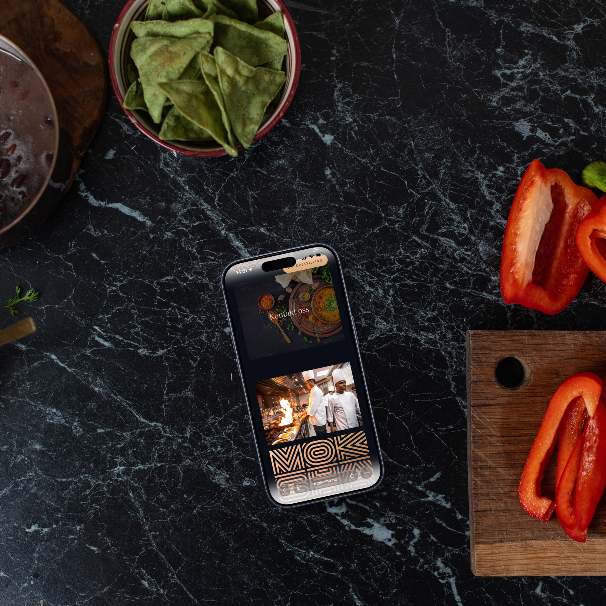 Bilde av en iphone som ligger på en kjøkkenbenk med paprika på siden