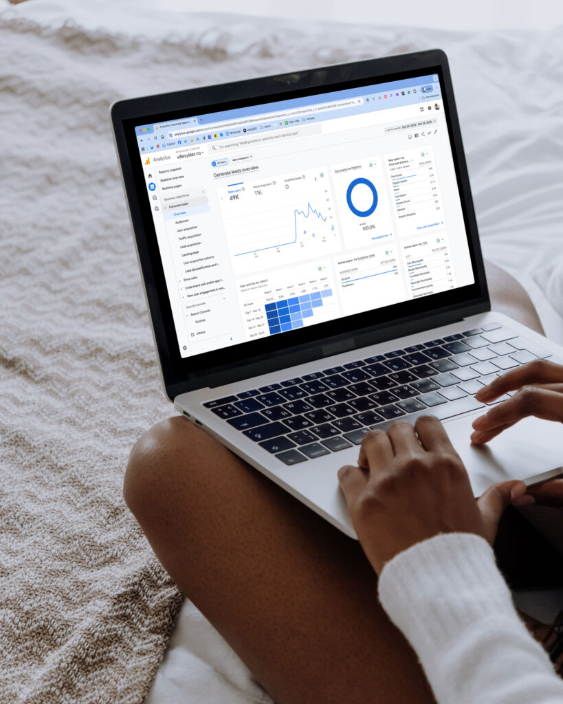 Bilde av en kvinne som sitter med laptopen i fanget og ser på brukerstatistikk gjennom Google Analytics for Villesykler.no
