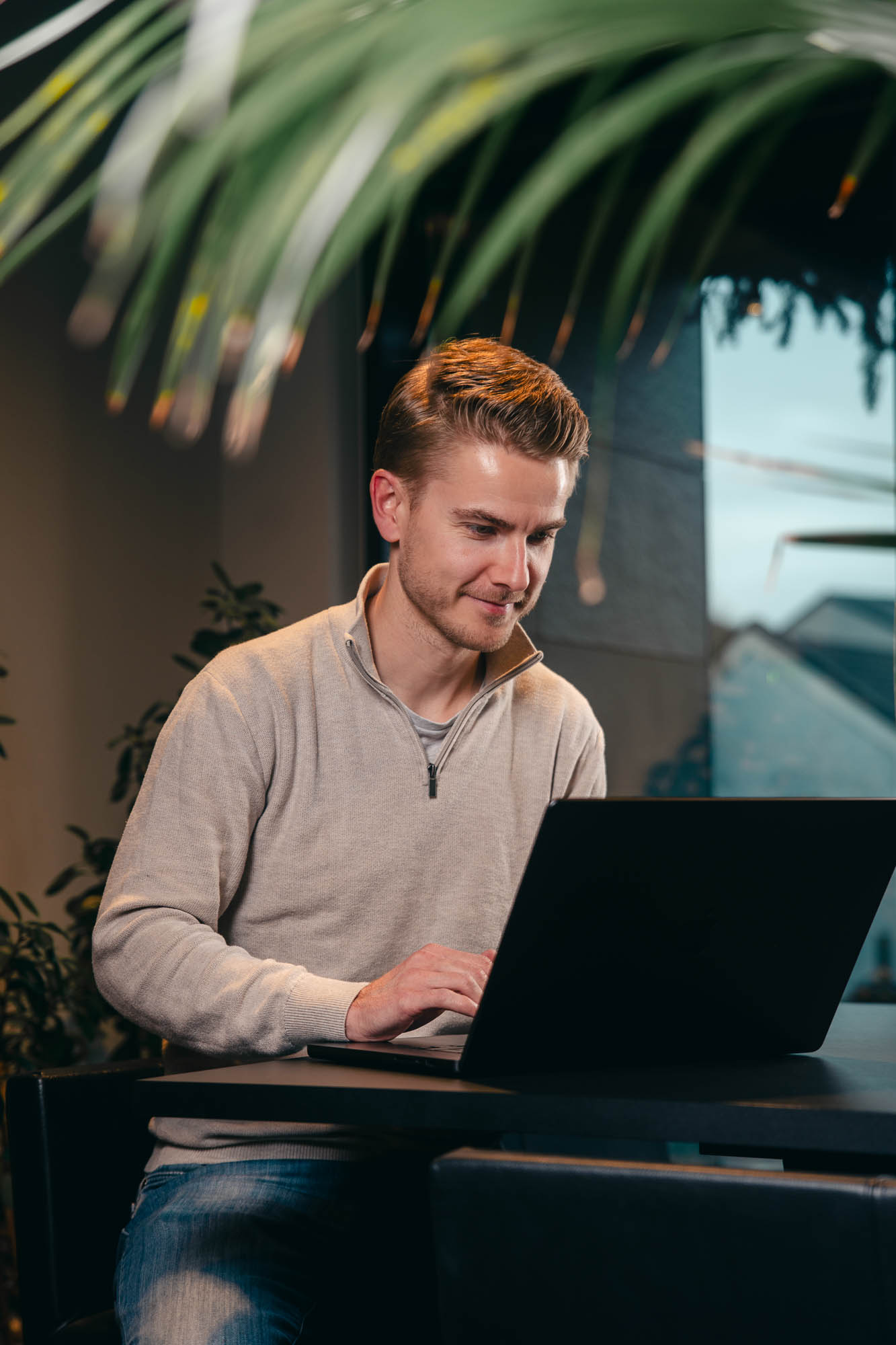 Bilde av en mann som sitter og jobber på en Mac